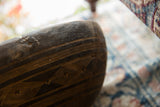 A primitive stitched repair and carved linear details on the dark, textured wood bowl.