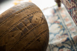 Angled detail of incised geometric patterns and lines on the vintage African wooden bowl.