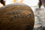 Dark wood vintage African bowl with intricate carved zigzag patterns.