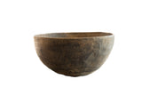 Vintage handmade African wooden bowl with a dark, weathered patina and rustic, textured surface.