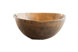 Vintage handmade African wooden bowl with a deep, time-worn patina and carved exterior.