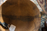 Aged patina and unique stitched repairs inside a handmade African wooden bowl.