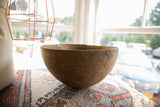 Traditional metal staple repair securing a historic crack on the vintage wooden bowl.