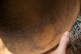 The time-worn texture and deep brown wood grain inside the African bowl.
