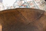 Close-up of a crack in the vintage wooden bowl with a metal staple repair.
