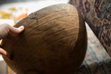 A close view of the textured wood and an antique metal staple repair on a crack.