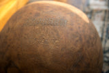 Wavy metal staples form a historic repair on the aged African wooden bowl.