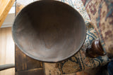 Deep, dark interior of a vintage African wooden bowl with natural wood grain visible.