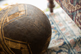 Close-up of vintage African wooden bowl, revealing dark wood grain and geometric carvings.