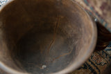 Vintage African wooden bowl interior, showing deep cracks and rich, aged patina.