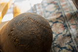 Aged patina and rustic texture on a dark vintage African wooden bowl.