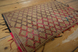 Detail of a Tuareg handwoven straw mat, featuring pink and black geometric weave.