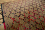 Interwoven straw texture of a vintage African Tuareg mat with red and black geometric design.