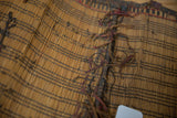 Texture of vintage Tuareg handwoven straw mat, dark geometric pattern, reddish-brown ties.