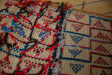 Detail of the reverse side's colorful threads on a vintage Tuareg straw mat.