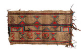 Vintage African Tuareg handwoven straw mat with red, blue, and black geometric patterns.