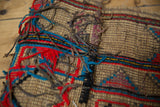 Textured handwoven detail of vintage Tuareg mat with colorful yarn and leather accents.