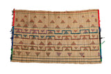 Vintage Tuareg straw mat with handwoven geometric patterns in red, green, and blue.