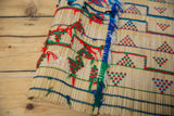 Handwoven straw and colorful yarn detail on a folded vintage African Tuareg mat.