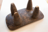 The bottom of a hand-carved Senufo stool showing its four tapered wooden legs.