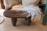 Vintage Senufo wood milk stool styled as a rustic decorative object in a living space.