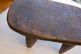 Aged dark wood surface of the vintage Senufo hand-carved milk stool.