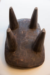 Dark, hand-carved wood texture and patina on the vintage Senufo stool surface.