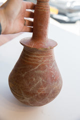 Antique North African pottery vase held in hand to show its form and scale.