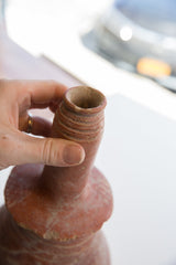 Detail of the ribbed neck and aged clay opening of an antique North African vase.