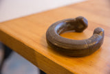 The sculptural form of an antique African snake cuff with a dark, time-worn patina.