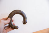 The scale and aged bronze patina of an African snake cuff bracelet held in hand.