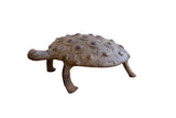 Dark aged vintage African turtle figurine with textured shell and concentric patterns.
