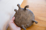 Handmade African turtle figure's textured underside, revealing dark finish and subtle gold patina.