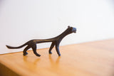 The sleek, stylized silhouette of a vintage African cheetah with dark patina.