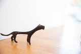 The sleek, stylized silhouette of the handmade African cheetah sculpture.
