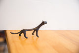 Side profile of the vintage cheetah sculpture, showing its elongated form and dark patina.