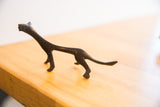 Side profile of the vintage cheetah sculpture highlighting its slender, elongated body.