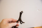 Detail of the handmade African cheetah showing its stylized legs and dark, textured patina.