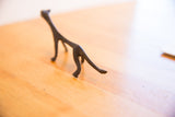 Rear profile of the vintage cheetah sculpture, showing its dark patina and lean shape.