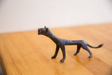 Side profile of the vintage cheetah's elongated body and textured dark patina.
