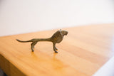 Elongated profile and rough, oxidized texture of a vintage African lion sculpture.