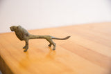 Elongated body and stylized form of a vintage oxidized African lion sculpture.
