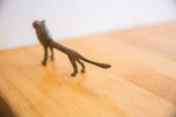 Vintage African lion collectible, showing aged metal texture on its tail and hind legs.