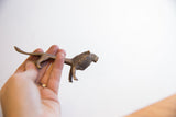 A vintage African lion figurine held to show its handmade texture and scale.