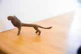 Side view of the vintage handmade African lion sculpture with aged texture.