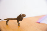Side view of the vintage lion highlighting its elongated body and rustic texture.