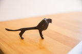 Profile view of a vintage African lion showing its dark patina and handmade form.