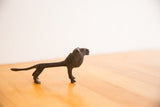 Side profile of the vintage African lion showing its slender form and dark patina.