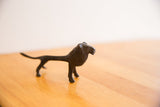 The stylized form and textured dark patina of a vintage African lion sculpture.