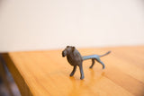 Profile view of a vintage African lion sculpture with a dark, textured patina.